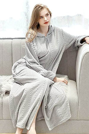 Woman wearing stylish flannel nightgown with zipper sitting on sofa, soft thick cozy fabric, hooded design.
