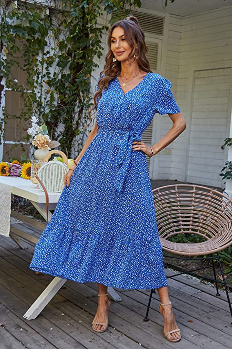 Woman wearing a blue Charming Floral Boho Maxi Dress with wrap V-neck and belted waist on a porch setting