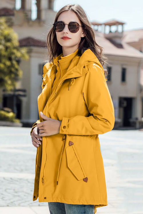 Woman wearing yellow slim-fit versatile chic two-piece windbreaker set with adjustable hood and waist outdoors