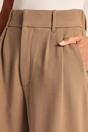 Close-up of beige Classically Vogue Business Trousers with high-waist and tailored fit showing hand in pocket