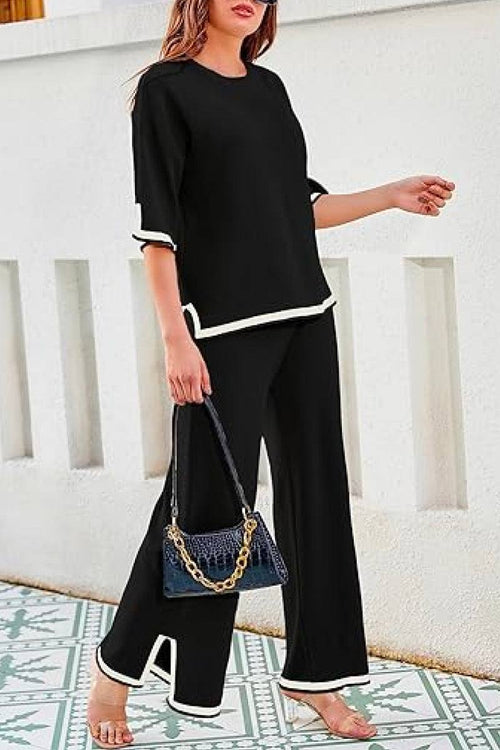 Black short sleeved relaxed fit lounge two-piece set with white trim and wide-leg palazzo pants.