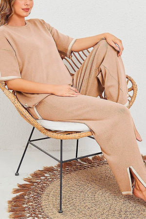 Woman wearing beige short sleeved relaxed fit lounge two-piece set sitting on a wicker chair