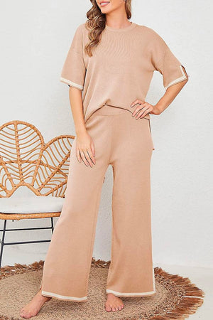 Woman wearing beige short sleeved relaxed fit lounge two-piece set with wide-leg pants standing indoors