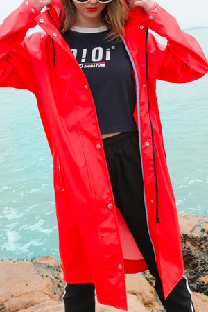 Lightweight ultra water-resistant long red windbreaker jacket for women with hood and zipper closure by the sea