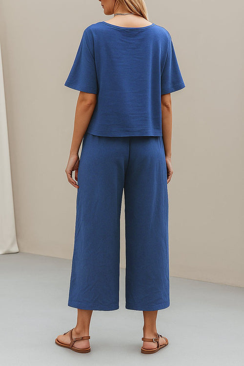 Woman wearing blue loose fit co-ord set with short sleeves and wide-leg pants standing indoors