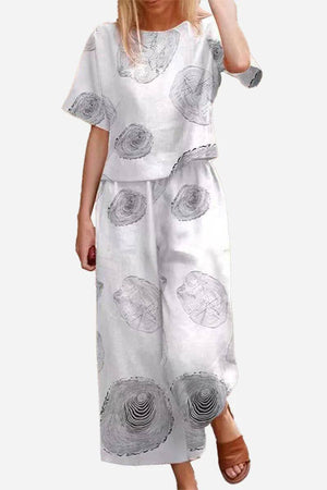 White loose fit co-ord set with wide-leg pants and short sleeve top featuring abstract circular prints