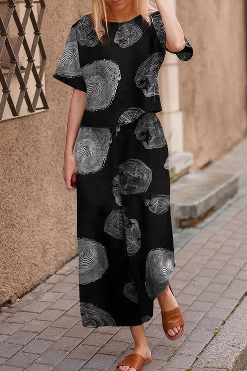 Woman wearing black floral print loose fit co-ord set with wide-leg pants and short-sleeve top