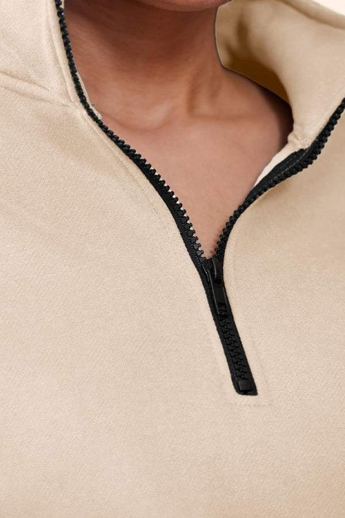 Close-up of beige ultra-soft and comfy co-ord tracksuit set with black zipper detail
