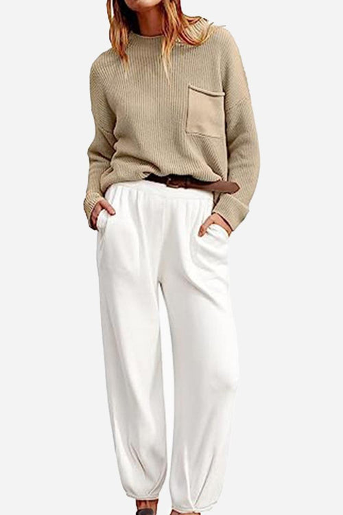 Woman wearing European minimalism relaxed khaki knit sweater with pocket and white loose trousers set