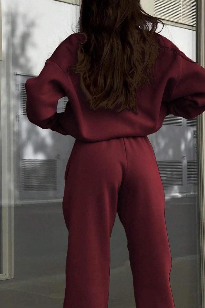Back view of a woman wearing a maroon cotton-blended two-piece tracksuit outdoors.