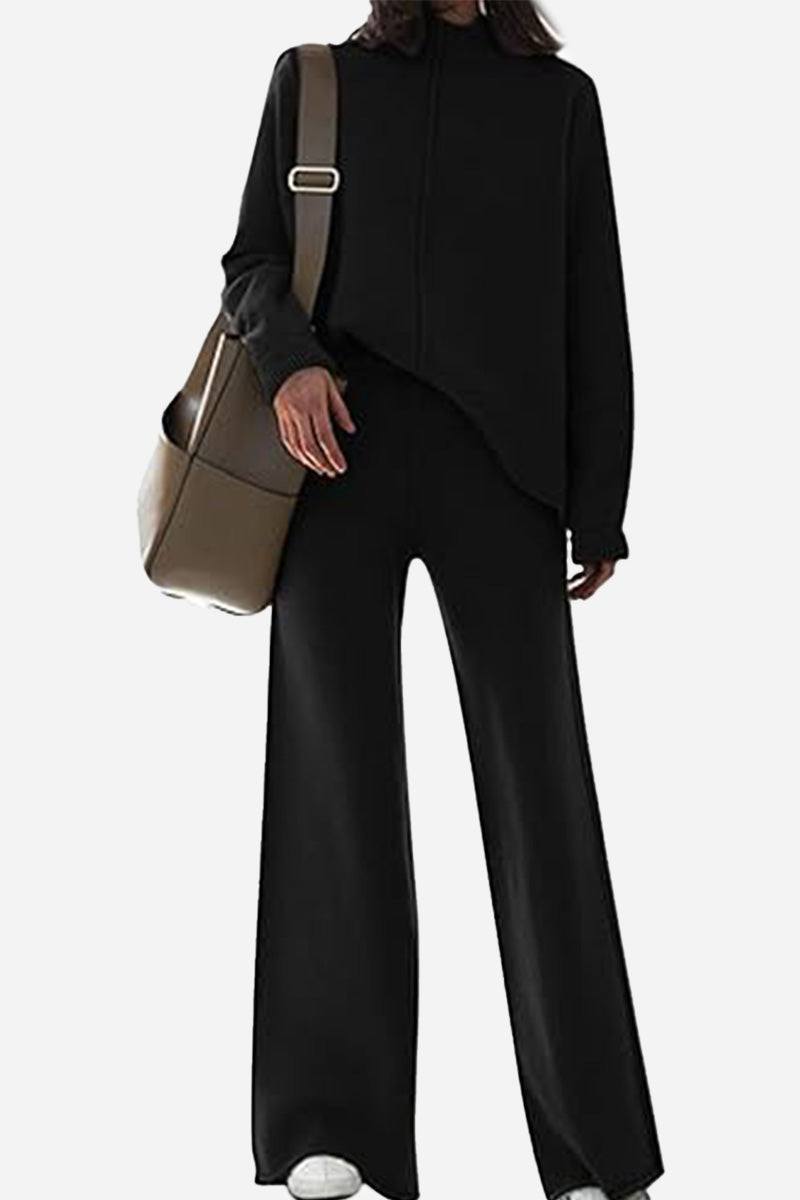 Woman wearing black high neck sweater and wide leg pants set carrying brown bag