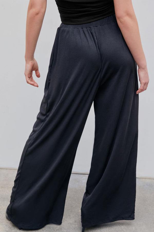 Back view of black stretchy wide-leg pants with elastic waistband for all-day comfort and flattering silhouette