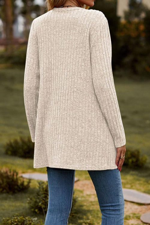 back view of a woman wearing a long lightweight ultra soft knit-like cardigan in beige outdoors