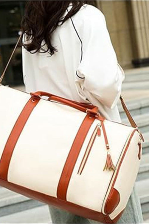 White and brown leather no-wrinkle foldable travel bag with shoulder strap carried by a woman