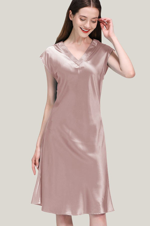 Woman wearing a soft pink Mulberry Silk V-Neck Nightgown with short sleeves and a flowing silhouette.
