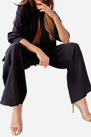 Professional black two-piece set with wide-leg pants and button-up top, styled for versatile business and casual wear