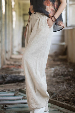 Side view of relaxed fit sandwashed ramie linen pants with plush lining in beige color and pockets worn by a person
