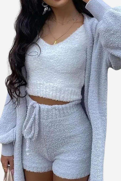 Woman wearing cozy white Cloud Soft 4-Piece lounge set with cardigan, crop top, and shorts made of plush fabric