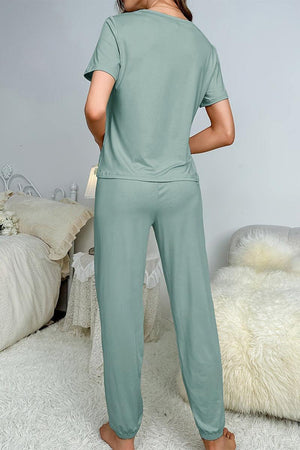 Back view of a woman wearing My Go To Loungewear soft green two-piece set in cozy bedroom setting