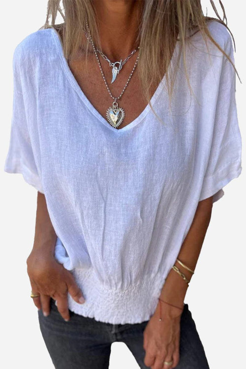 White pure linen short-sleeve blouse with V-neck and relaxed fit on woman