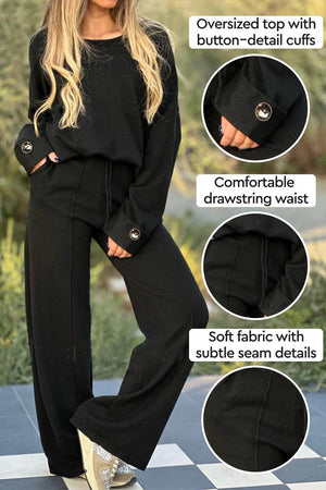 Black comfortable two-piece set with oversized button-cuff top and wide-leg drawstring pants, soft fabric and subtle seam details
