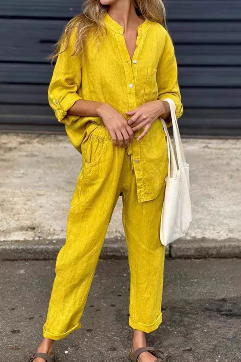 Woman wearing yellow casual chic two-piece set with button-up shirt and relaxed pants carrying white tote bag