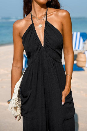 Sunshine On Sand black halter-neck jumpsuit with ruched neckline and wide-leg silhouette at the beach