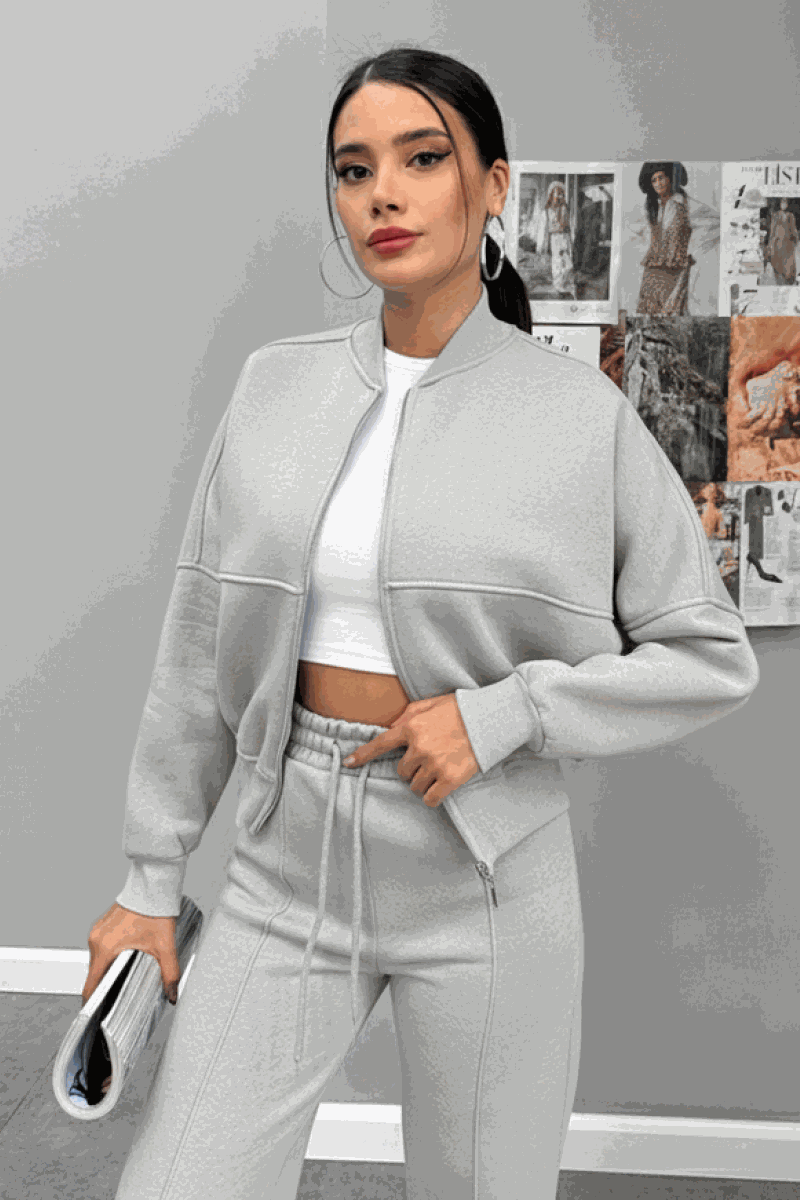 Woman wearing The Voyager Zip Set light grey zip-front sweatshirt and wide-leg joggers with pockets, stylish travel outfit