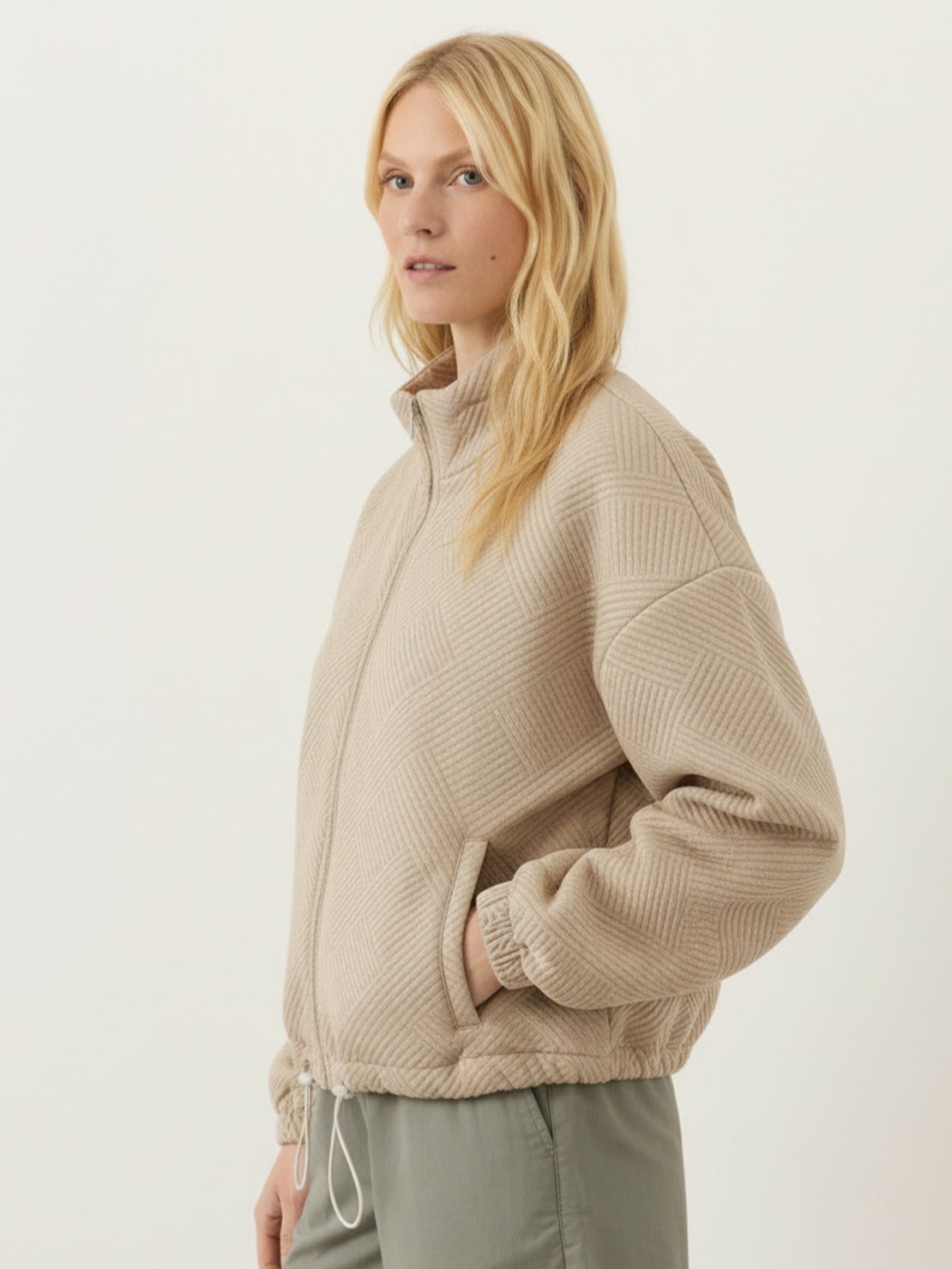 Cropped textured baseball jacket with full zipper, stand collar, elastic cuffs, and waistband designed for casual layering.