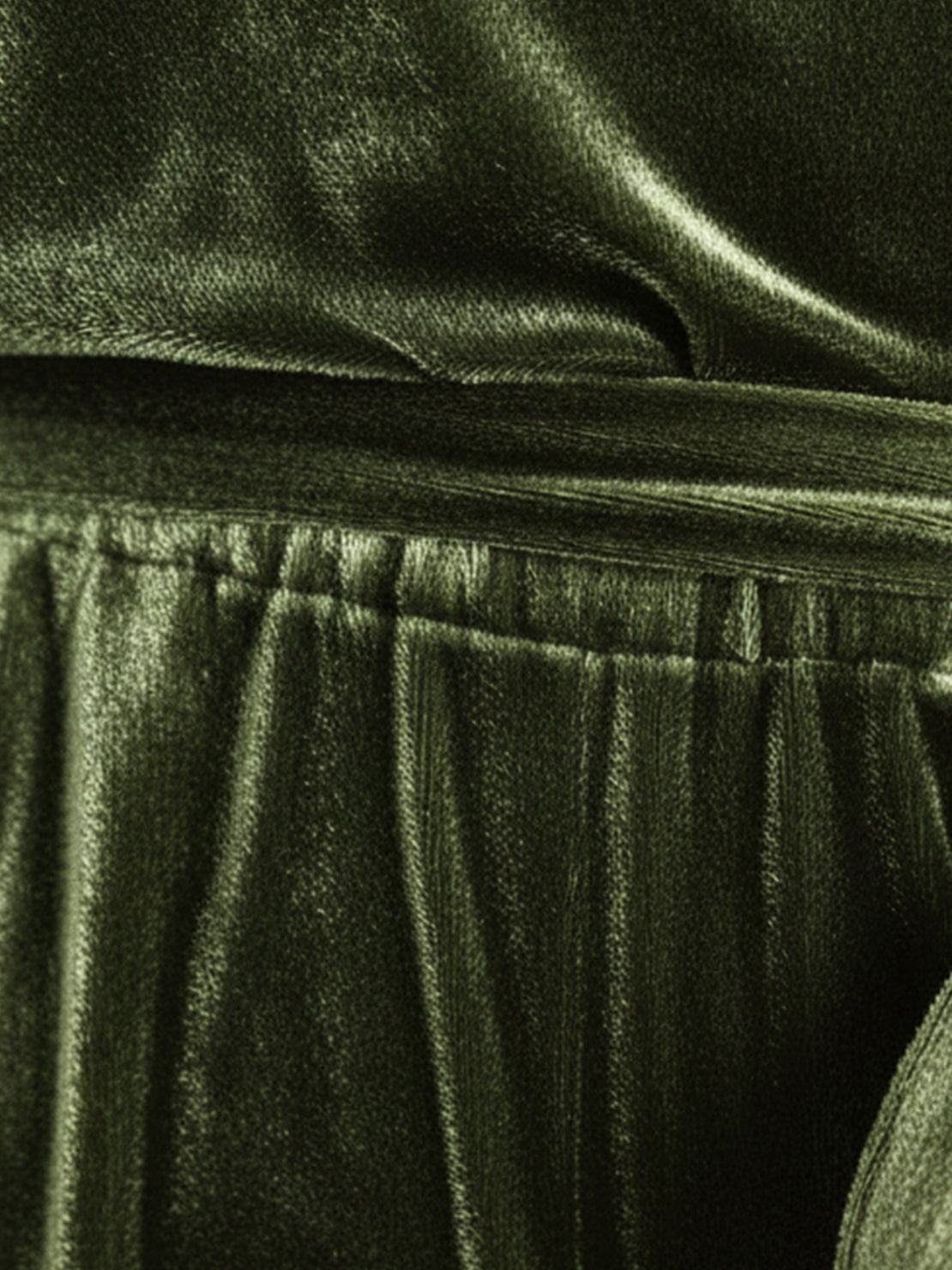 Woman wearing deep V-neck velvet suit with long sleeves and wide-leg pants