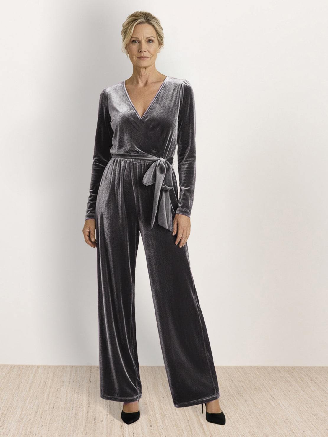 Woman wearing deep V-neck velvet suit with wide-leg pants and removable waist tie