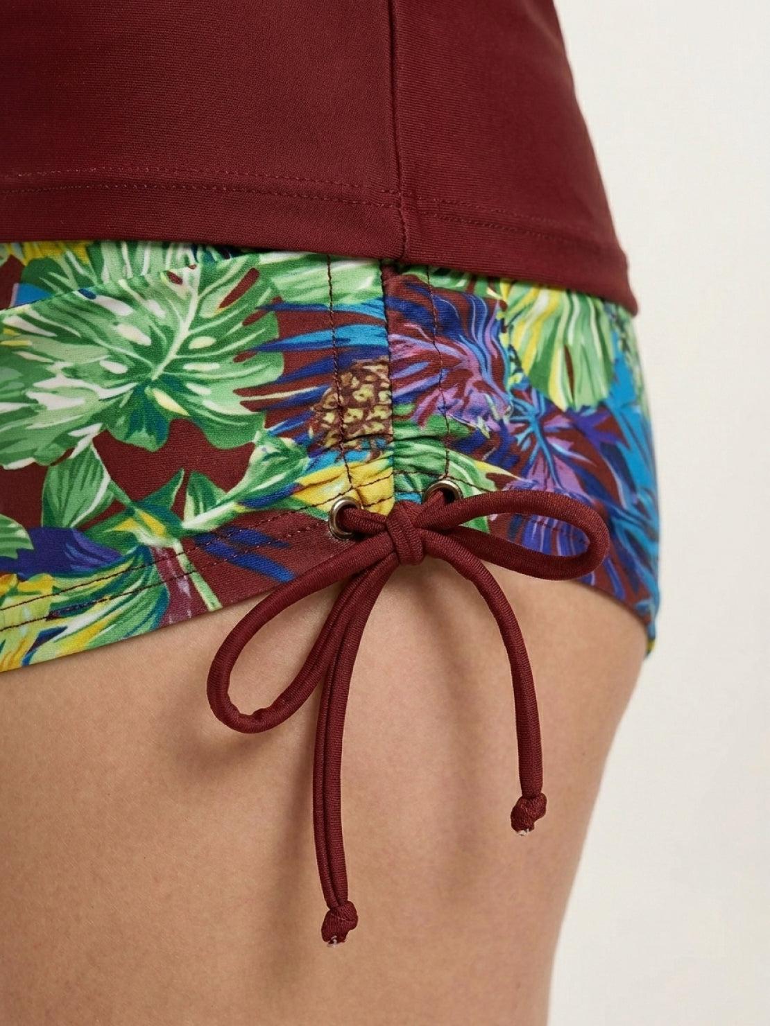 Two-piece tropical print rash guard set with long sleeves and boy-cut swim shorts