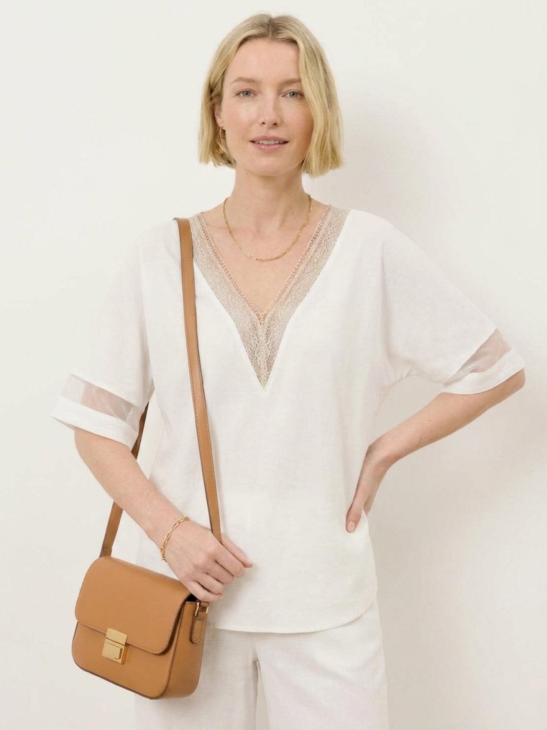 Mature woman wearing a lightweight linen top with V-neck and three-button detail in a relaxed boxy shape