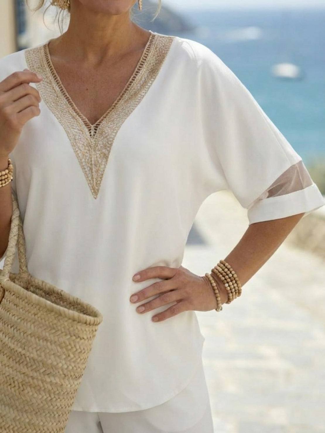 Mature woman wearing a lightweight linen top with V-neck, short sleeves, and button details in light khaki
