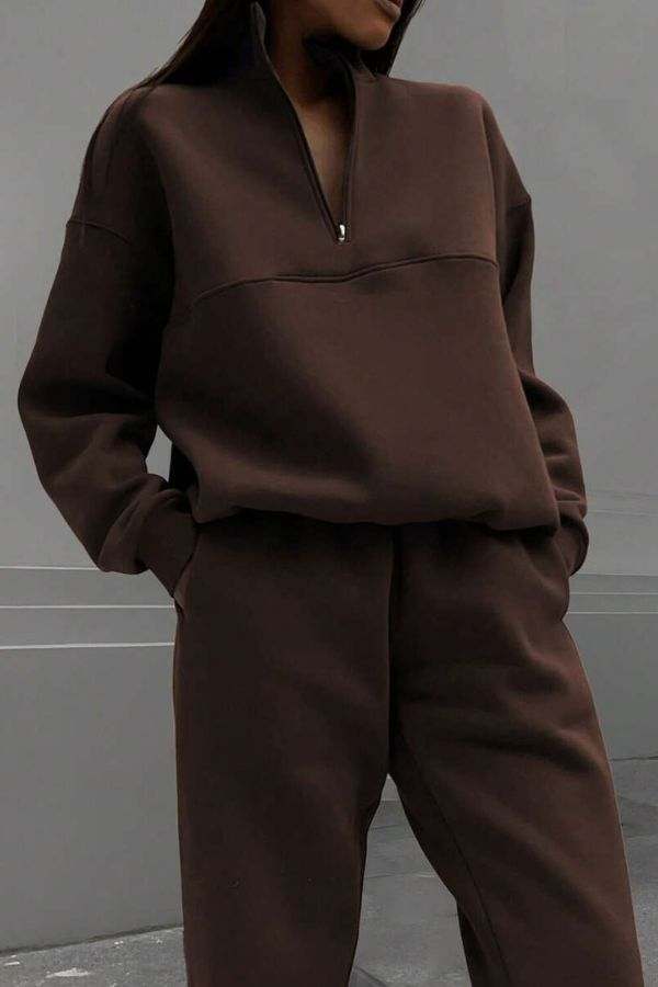 woman wearing cotton-blended two-piece tracksuit with high collar and zipper in monochrome design