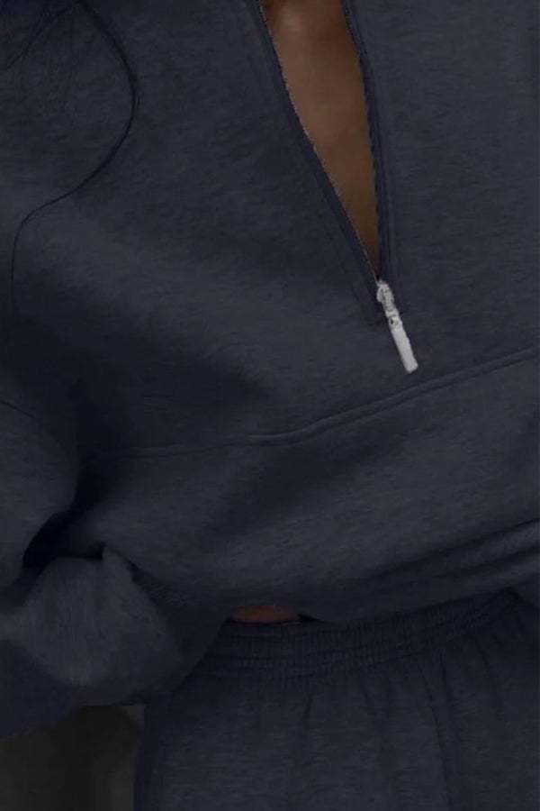 woman wearing a cotton-blended two-piece tracksuit with high collar and zipper, matching monochrome design, casual athleisure look