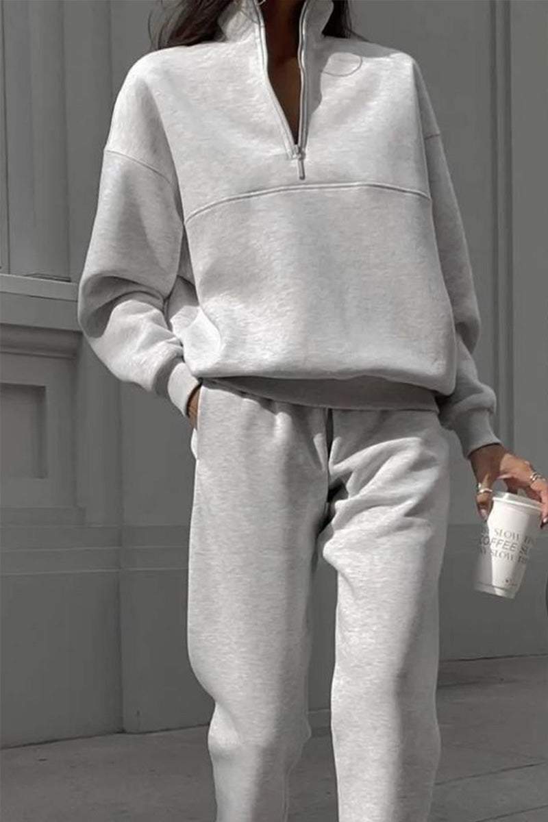 woman wearing cotton-blended two-piece tracksuit with high collar and zippered jacket in monochrome solid color