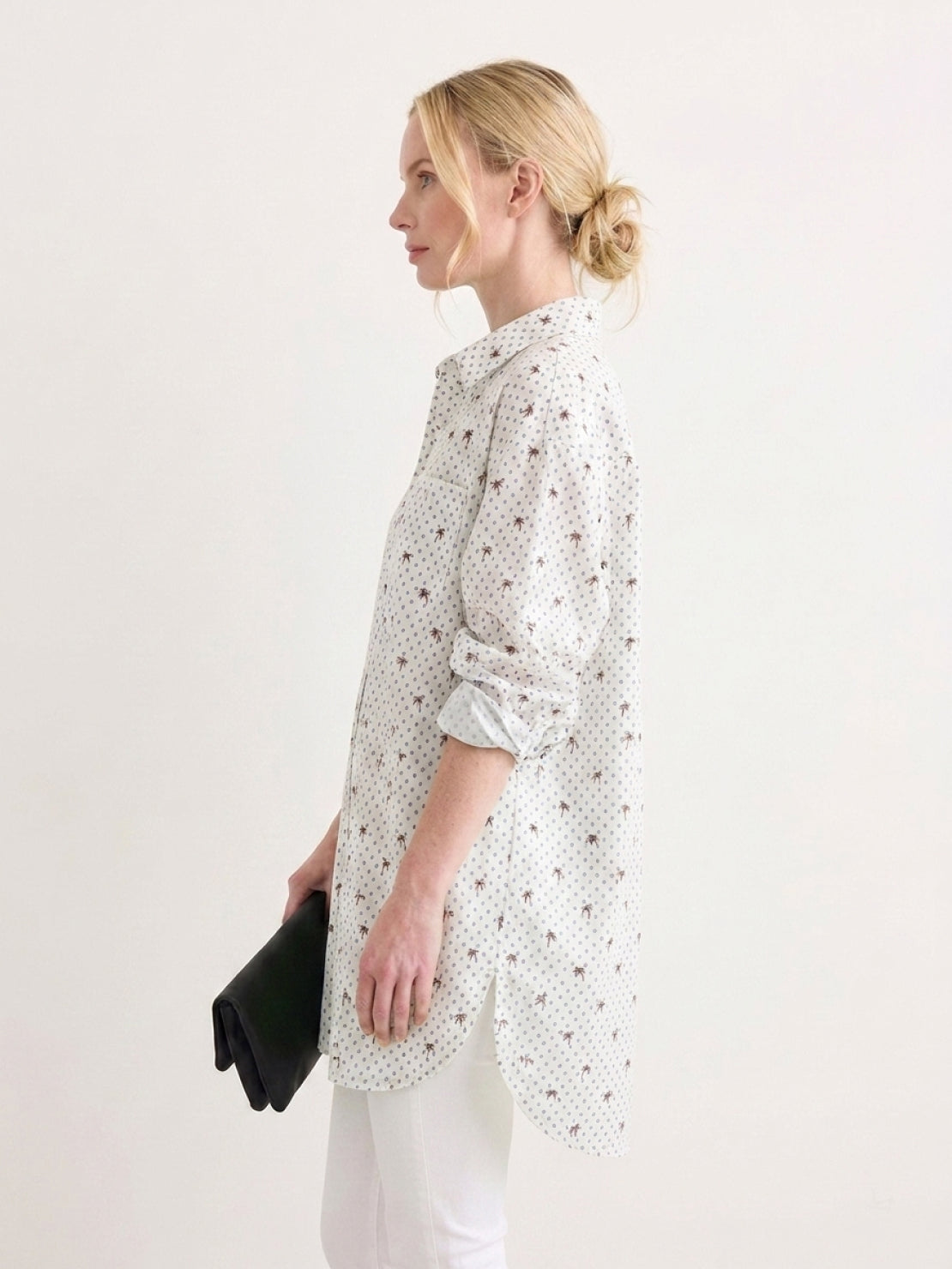 Woman wearing oversized linen shirt in relaxed fit with back-pleat button detail