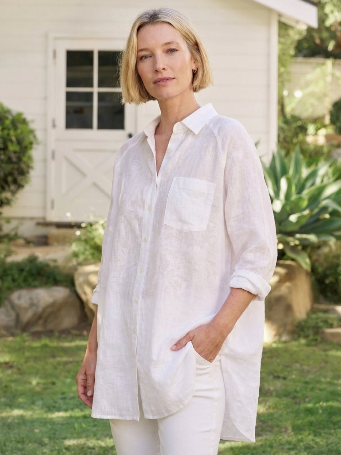 White oversized linen shirt with back pleat and button-up design on mannequin
