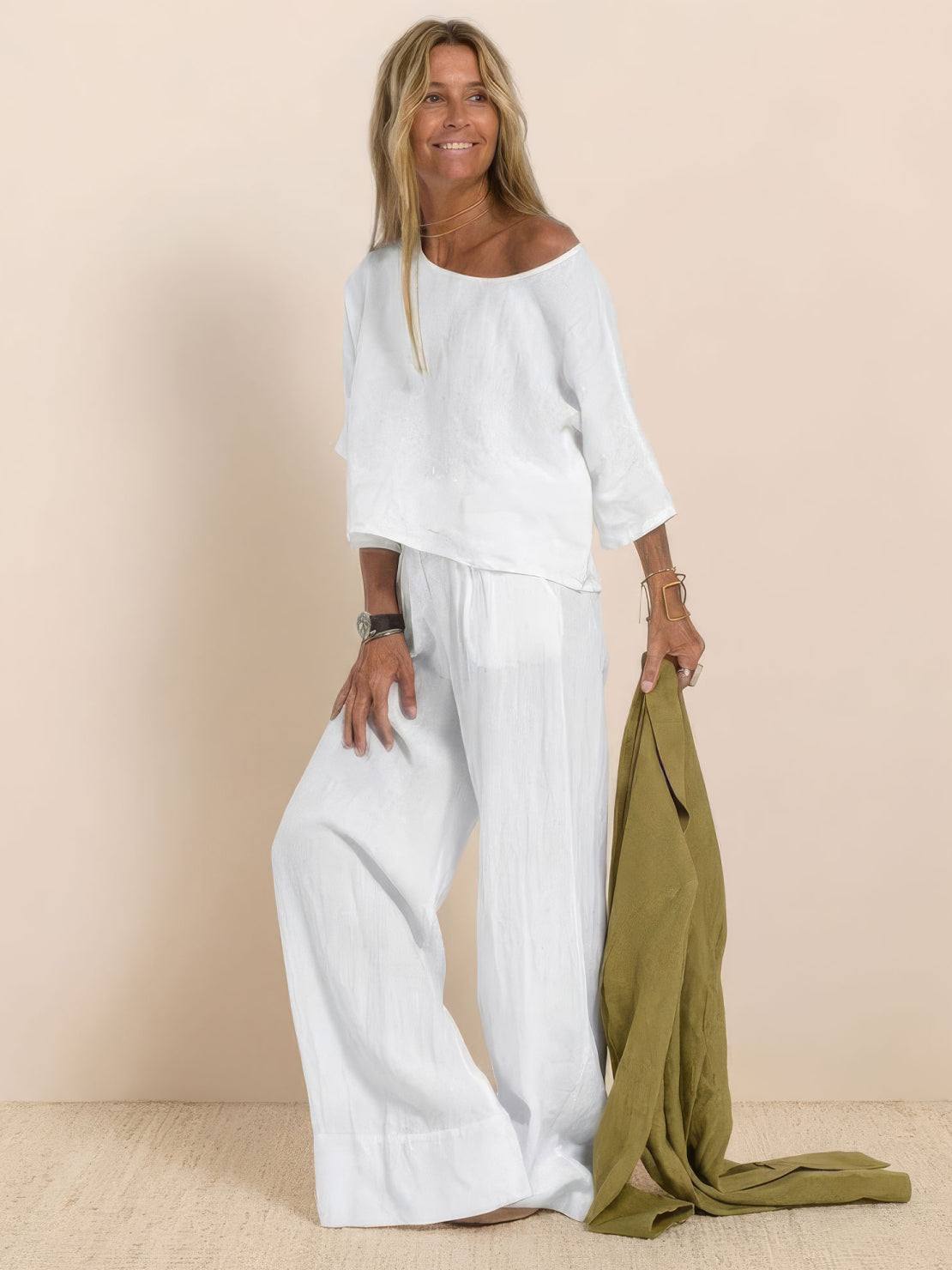 woman wearing white short-sleeved pullover and wide trouser matching set holding olive green fabric