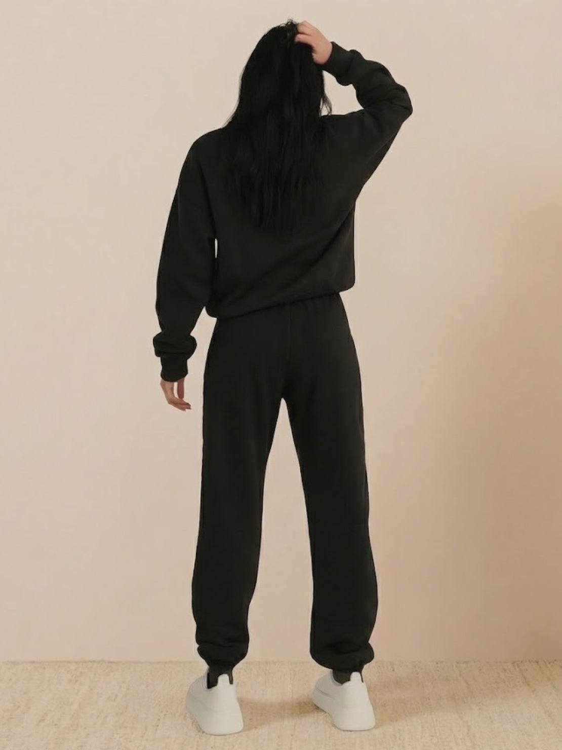 woman wearing black cotton-blended two-piece tracksuit with high collar and zipper outdoors