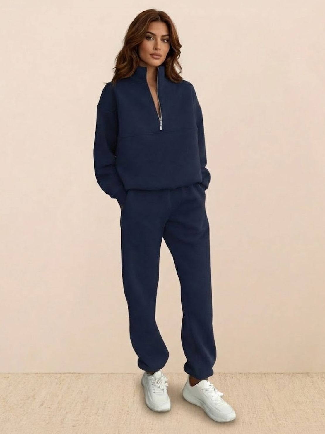 Woman wearing cotton-blended two-piece tracksuit with high collar and zipper, styled for casual athleisure look