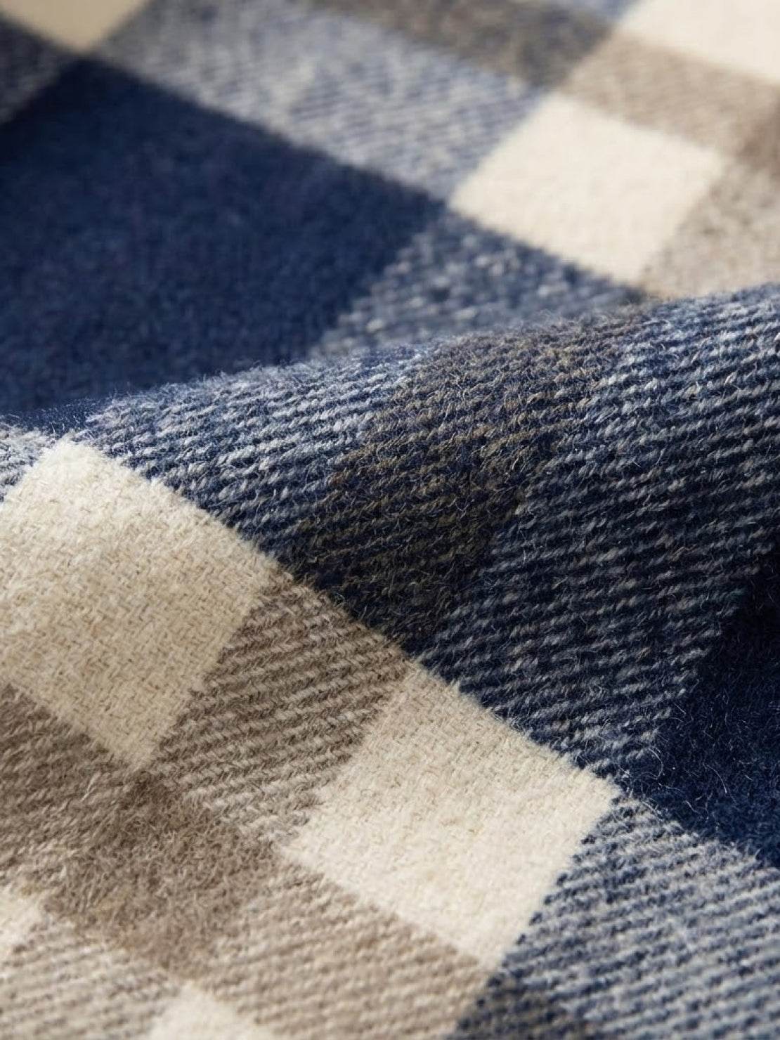 Close-up of comfy flannel classic plaid fabric in blue, beige, and cream colors
