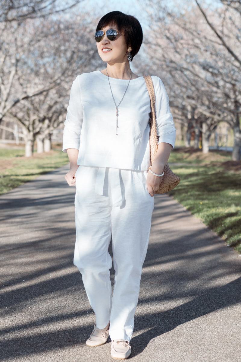 Woman wearing relaxed cotton-linen monochrome capsule outfit with longline top and wide-leg pants outdoors