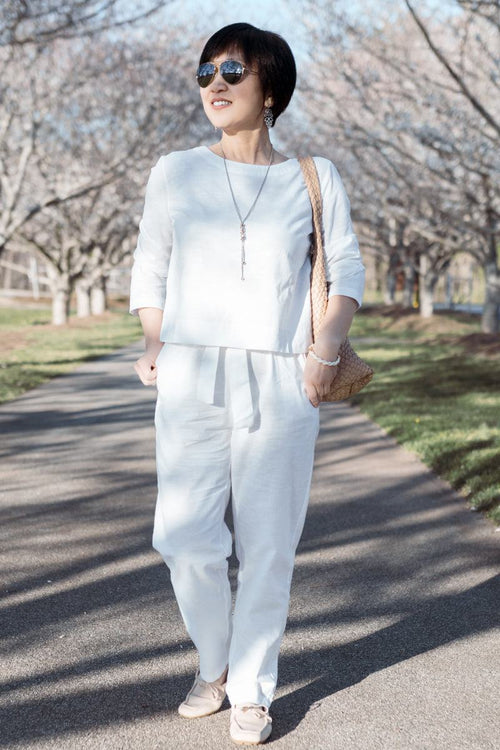 Woman wearing relaxed cotton-linen monochrome capsule outfit with longline top and wide-leg pants outdoors