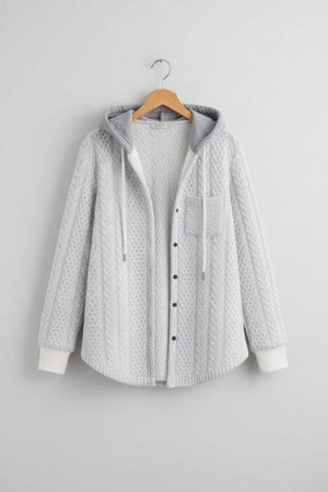 Light grey Highland Plaid Shacket with hood, button-front closure, and front pocket hanging on wooden hanger against grey wall