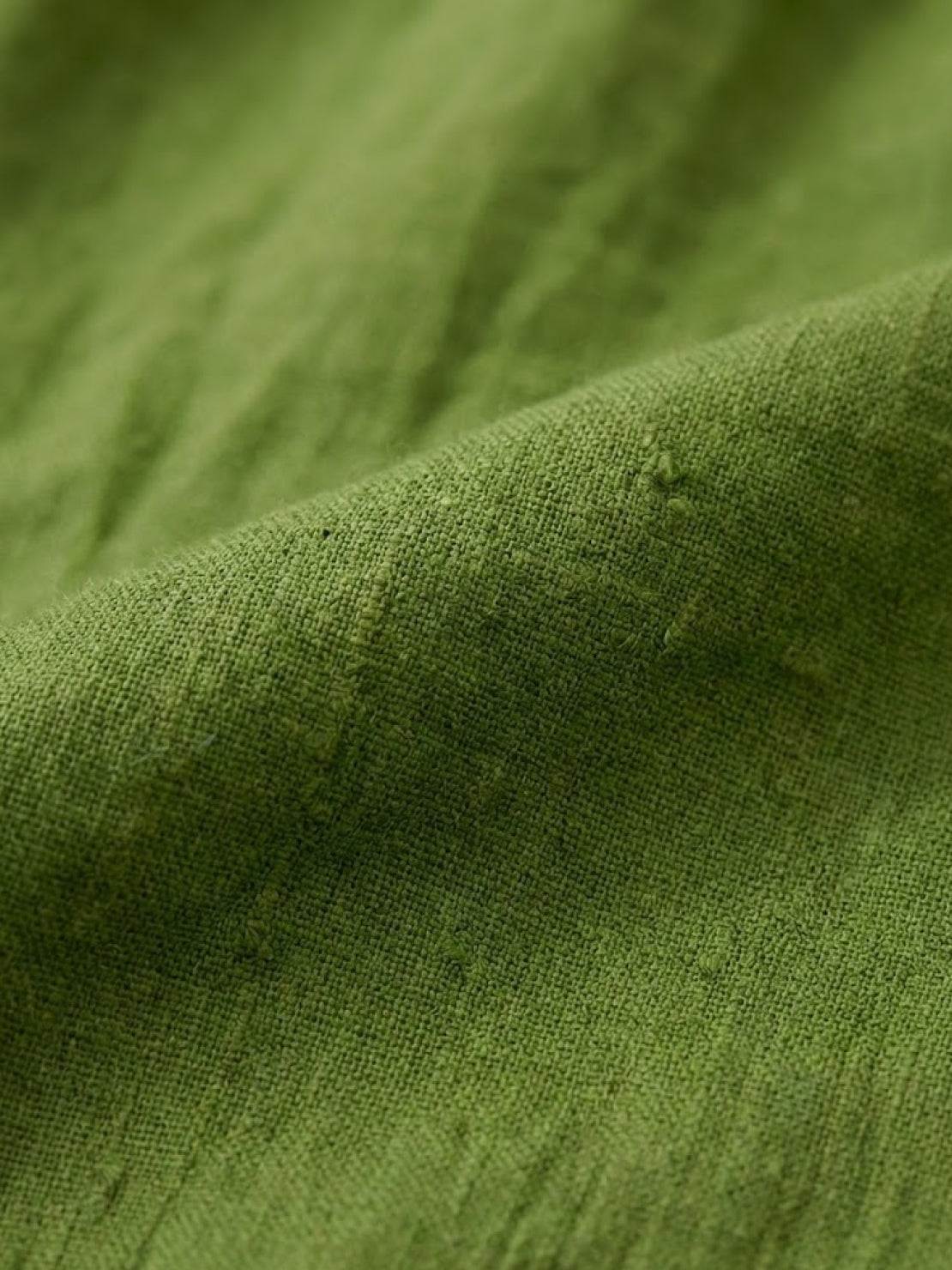 Green loose solid color linen-feel fabric close-up for breathable two-piece set