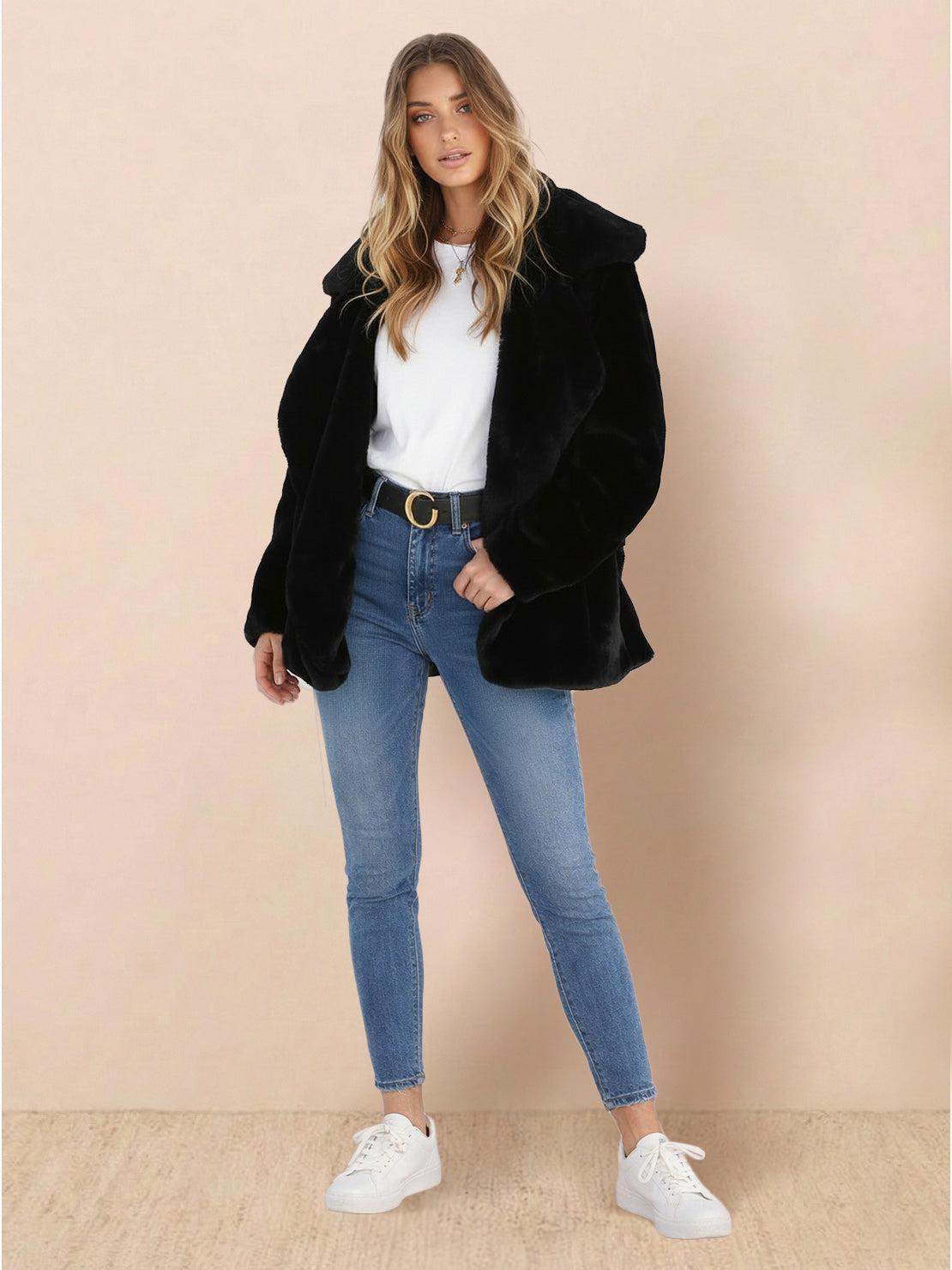 Open front oversized black faux fur jacket with draped collar, mid-hip length, and relaxed fit worn with jeans and white sneakers