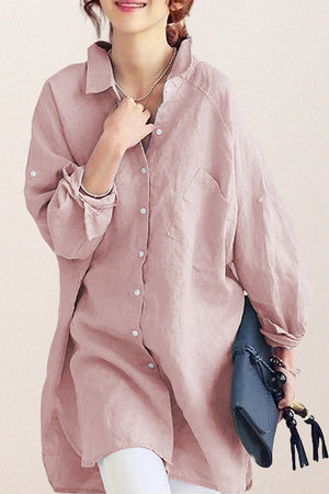 Oversized linen shirt in sun-washed pink with relaxed fit and button details, styled with white pants and a blue clutch.