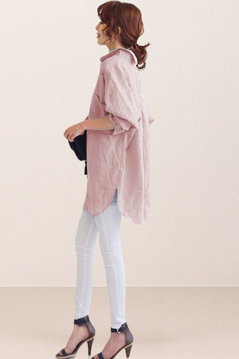 Woman wearing oversized linen shirt in sun-washed pink with rolled-up sleeves and white pants